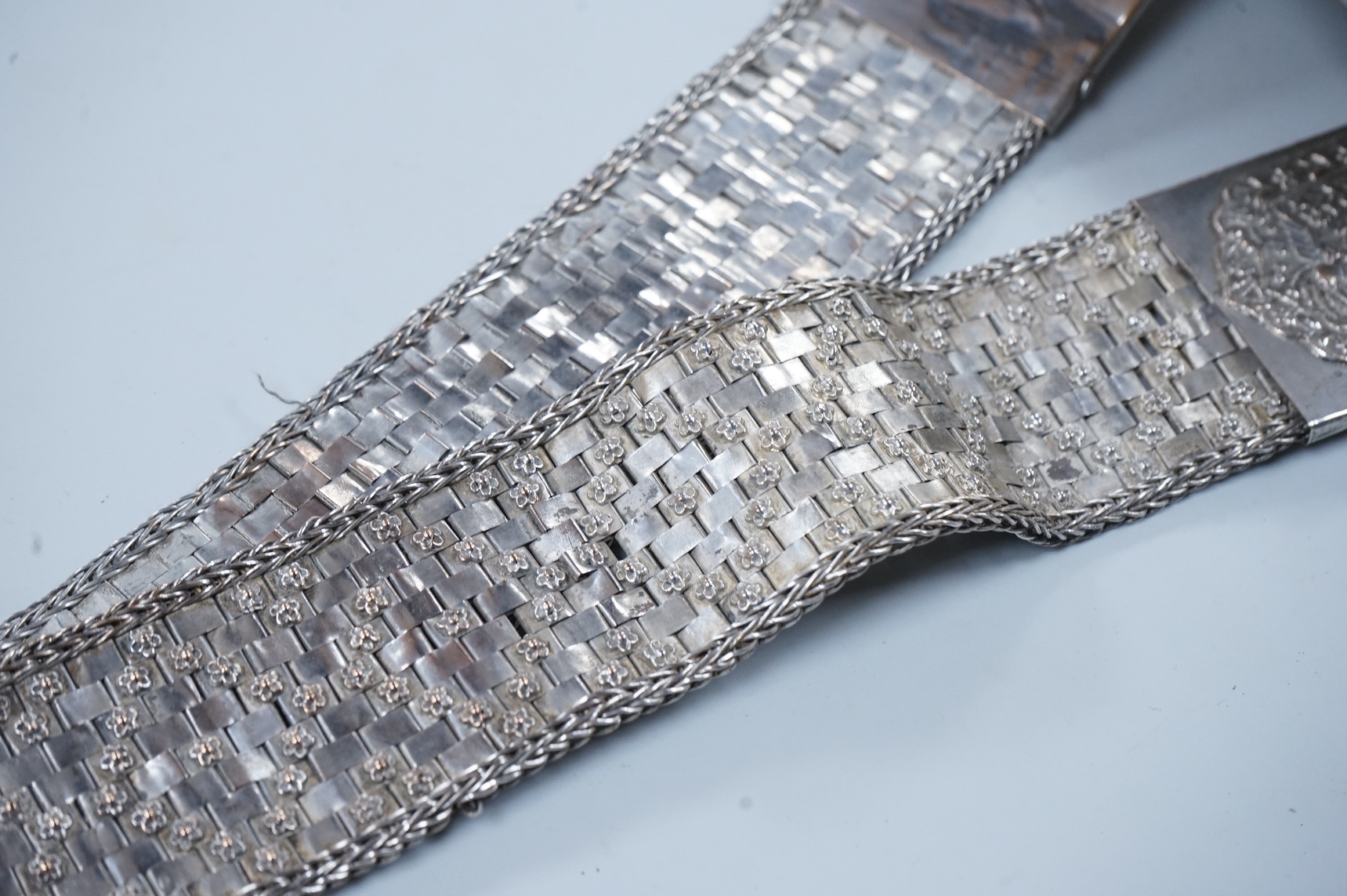An early 20th century Chinese Straits repoussé white metal belt and buckle, stamped marks, 273g